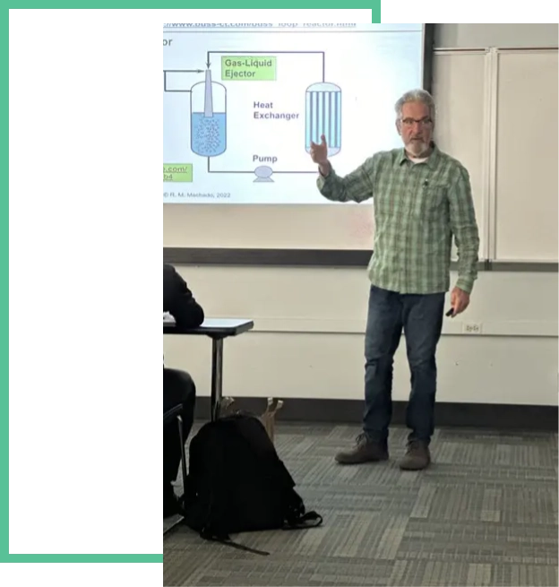 A man standing in front of a projector screen.